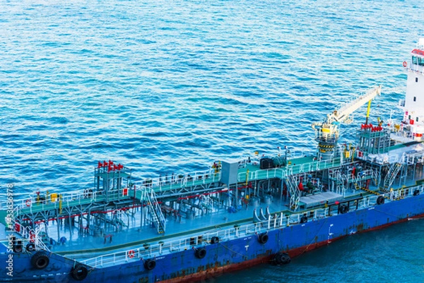 Fototapeta Close-up aerial view on the tanker ship, fuel bunker barge in the container terminal, she is arriving to supply large cargo ship with fuel oil. 