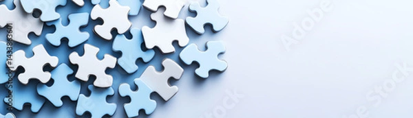 Fototapeta Scattered blue and white puzzle pieces on light background, symbolizing teamwork, problem solving, and project planning success