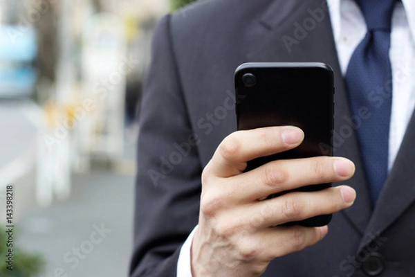 Obraz 外回りや通勤中スマホを使うビジネスマン男性の顔なしイメージ素材