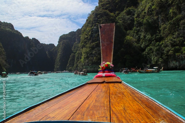 Obraz A point-of-view shot from a longtail boat, focusing on the iconic boat tail while beautiful limestone cliffs rise in the background.