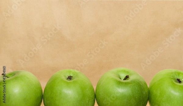Obraz Green juicy fresh apples on brown old paper background. Organic healthy food concept. Fresh raw farm fruits. Free space for text