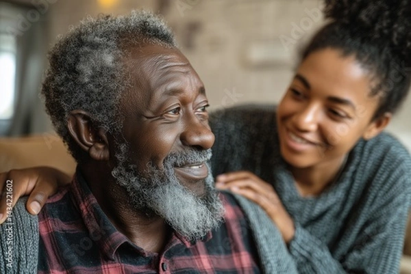 Obraz Elderly African man being assisted by a caring young caregiver in a home environment, concept of compassion and support.
