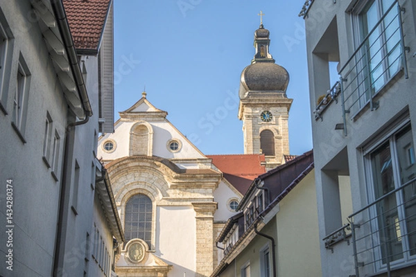 Obraz Kirchengebäude und Kirchturm der Konviktskirche im barocken Architekturstil hinter modernen Wohngebäuden in Ehingen an der Donau