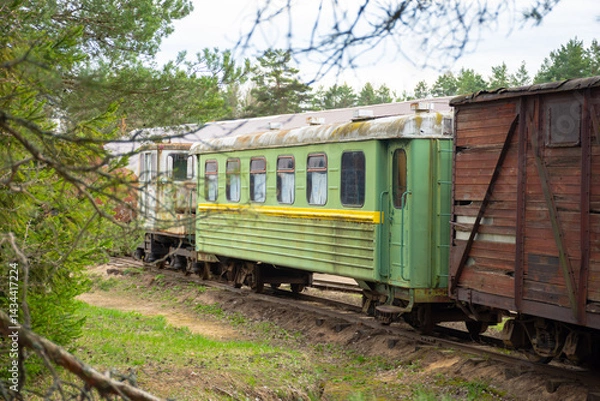 Fototapeta Green train car is parked on the tracks. The train car is old and rusty
