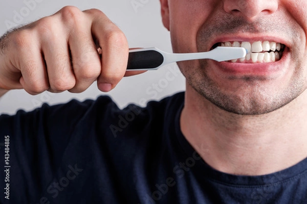Obraz man cleaning teeth with tooth brush