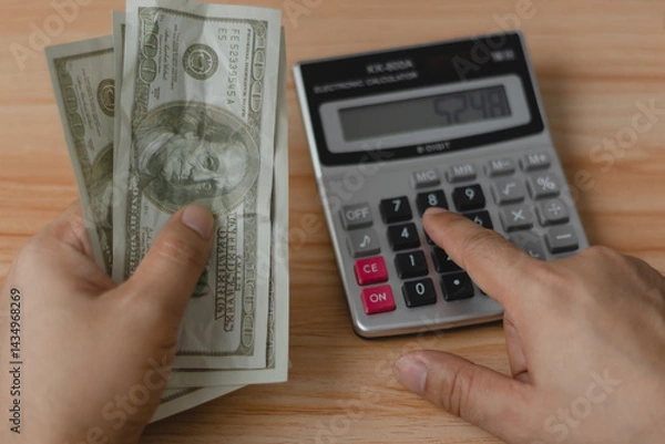 Obraz A man meticulously counts dollar bills, reflecting the concept of currency management in investments, salaries, shopping, and business transactions.
