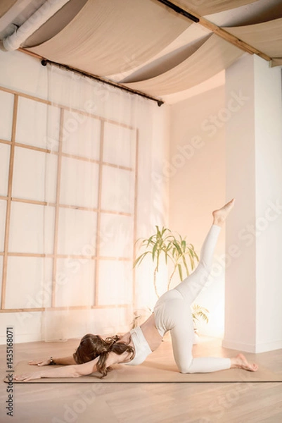Fototapeta Soft light fills yoga studio as woman holds pose with balance and grace, light enhances peaceful mood and visual beauty composition breathes harmony and calm aesthetics of modern wellness