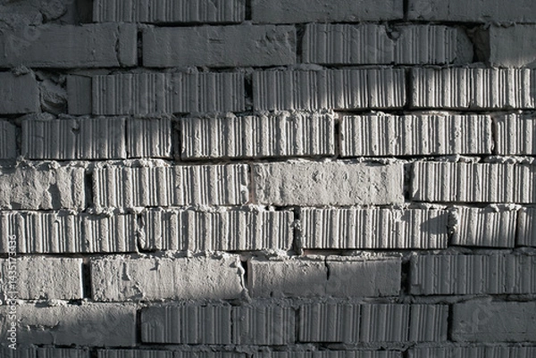 Obraz Fragment of brickwork, close-up. Brick wall, close-up. Potholes and defects in a brick wall, flat layout. Cracks and defects in bricks on a wall, color fantasy.