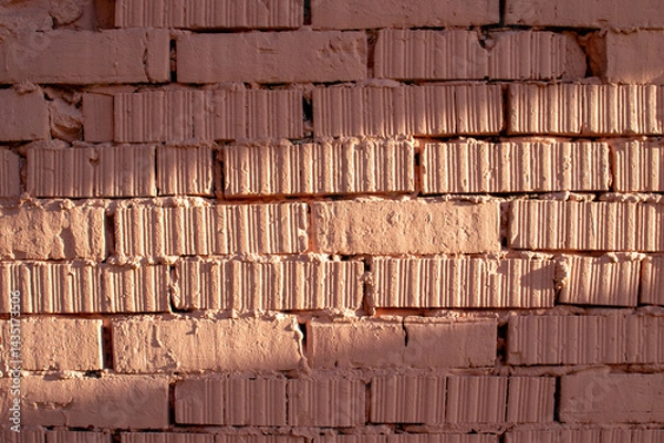 Obraz Fragment of brickwork, close-up. Brick wall, close-up. Potholes and defects in a brick wall, flat layout. Cracks and defects in bricks on a wall, color fantasy.