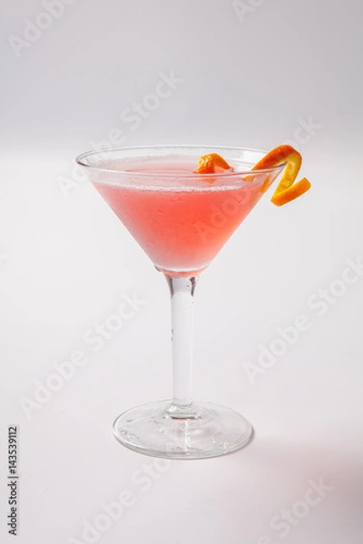 Fototapeta Red cocktail with orange garnish on a whithe background