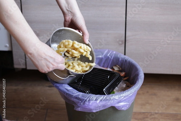 Fototapeta Person Throwing Leftover Pasta Into Trash Bin. Compost from leftover food, Environmentally Responsible