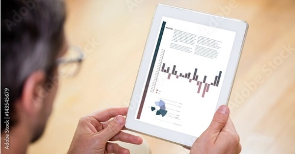 Obraz Businessman analyzing graphs on digital tablet