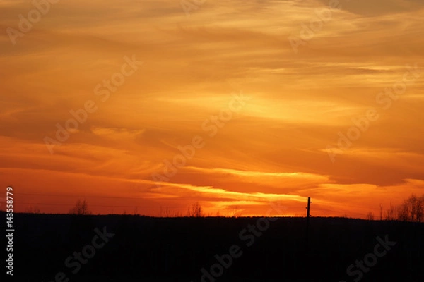 Fototapeta Beautiful orange sunset in the cloudy sky