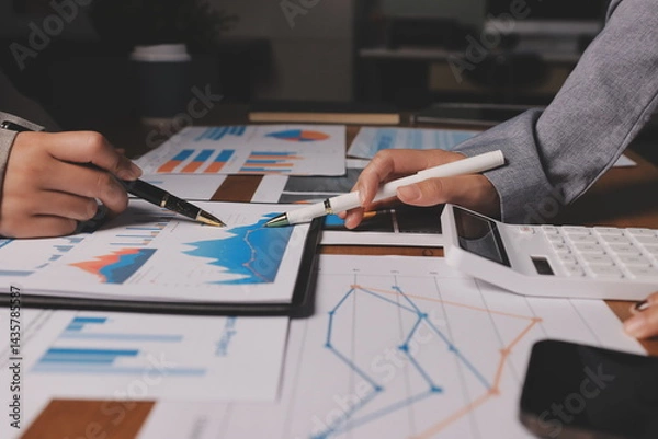 Fototapeta Group of confident business people point to graphs and charts to analyze market data, balance sheet, account, net profit to plan new sales strategies to increase production capacity.