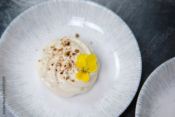 Obraz Elegant dessert garnished with edible flowers on a porcelain plate