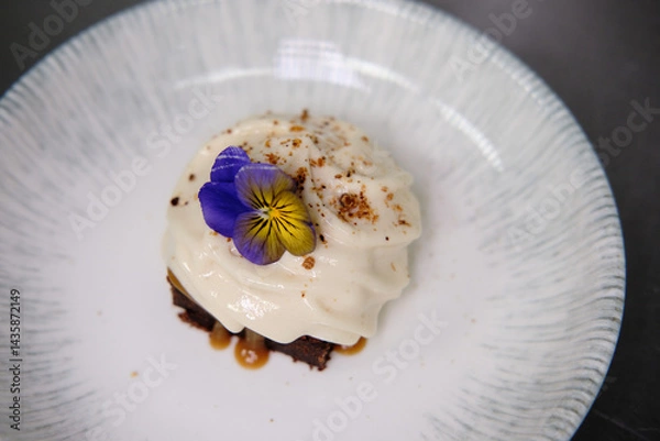 Obraz Elegant dessert garnished with edible flowers on a porcelain plate