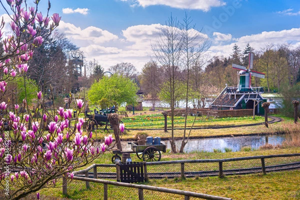 Obraz Scenic view of a scaled Dutch windmill and milk cart in amusement and theme park Efteling, The Netherlands.