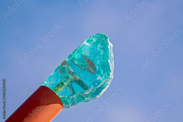 Obraz A large turquoise crystal on a metal tube reaches toward the blue sky