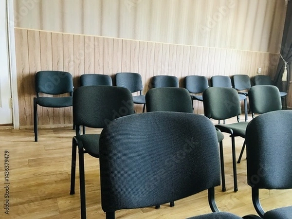 Fototapeta Empty chairs arranged in a room before an upcoming event