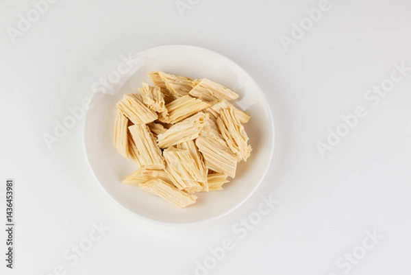 Fototapeta Tofu skin or yuba in a white plate top view isolated on white background