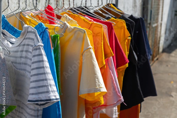 Obraz Colorful t-shirts hanging on a clothesline outdoors in sunlight