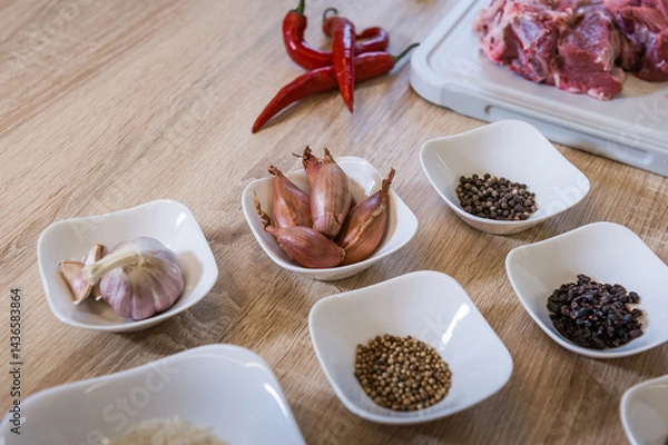 Fototapeta Spices arranged in bowls during cooking pilaf. Background of the kitchen interior.