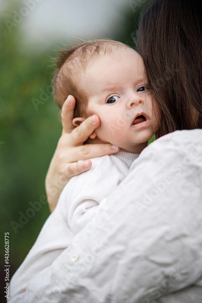 Fototapeta Mother kissing and hugging cute newborn baby in the garden, close up. Love, care and family in countryside concept. Happy Mothers day! Adoption and maternity