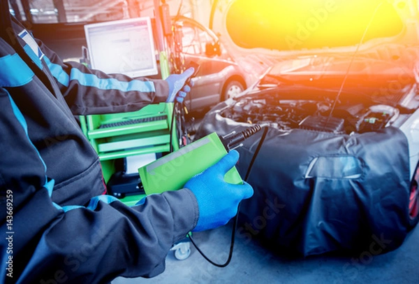 Fototapeta Professional car mechanic working in auto repair service.