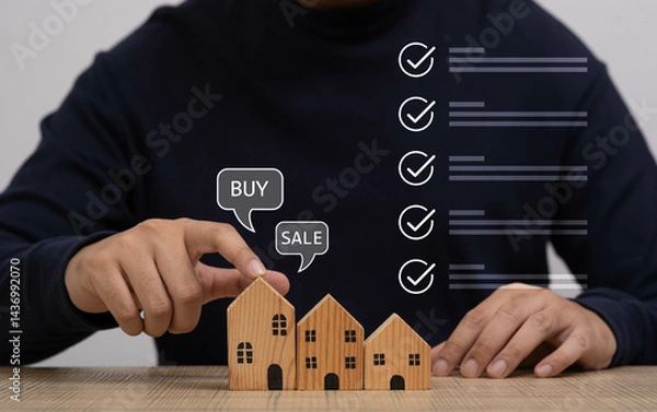 Fototapeta A person interacting with miniature wooden houses representing the real estate market, emphasizing the concepts of buying and selling properties.