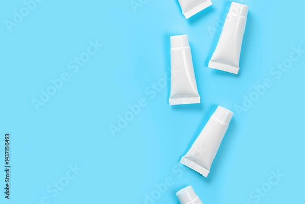 Fototapeta White closed tubes on the right side on blue background.