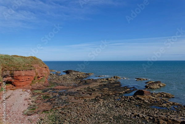 Fototapeta The Beach at Whiting Ness at the Arbroath Cliffs Coastal Walk with the weathered Rock strata uncovered at low tide on an April Morning.