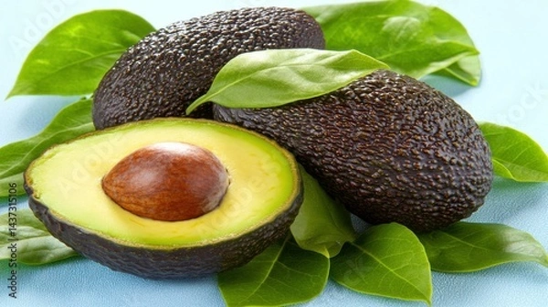Obraz Fresh Avocado Halved with Dark Skin and Leaves on Blue Background