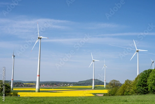 Fototapeta Wind turbines with green and yellow fields seen in Germany