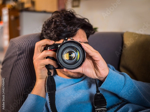 Fototapeta Person enjoying photography indoors while sitting on a couch