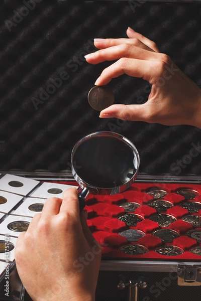 Fototapeta Hands with coin and magnifying glass, soft focus background