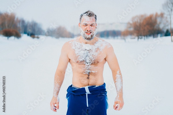 Obraz Portrait of russian bearded bodybuilder standing without clothes outdoors in winter on a frozen snowy lake with different emotions and posing for camera