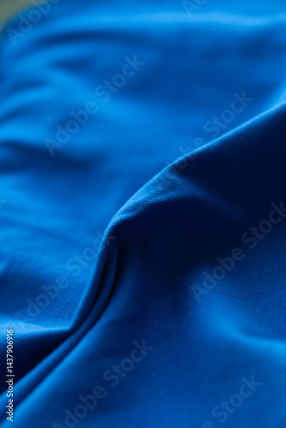Obraz Experience the vibrant energy of this captivating blue fabric, with its smooth texture and dynamic folds creating a mesmerizing visual.