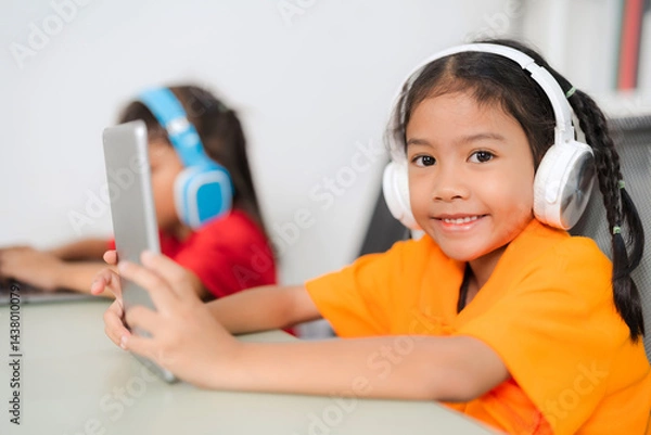 Fototapeta Two young asian students using laptop and tablet for online education