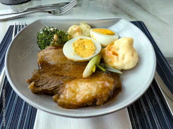 Fototapeta Close up view of roast beef in gravy with various vegetables and sliced egg