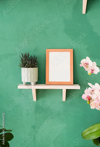 Fototapeta white small frame mockup on shelf with decoration objects, rustic green wall