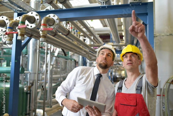 Obraz businessman and worker meeting in a factory - maintenance and repair of the industrial plant