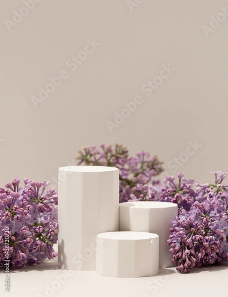 Obraz Elegant minimalistic spring-themed product display with white geometric pedestals surrounded by fresh lilac flowers on soft neutral background. Vertical photography.