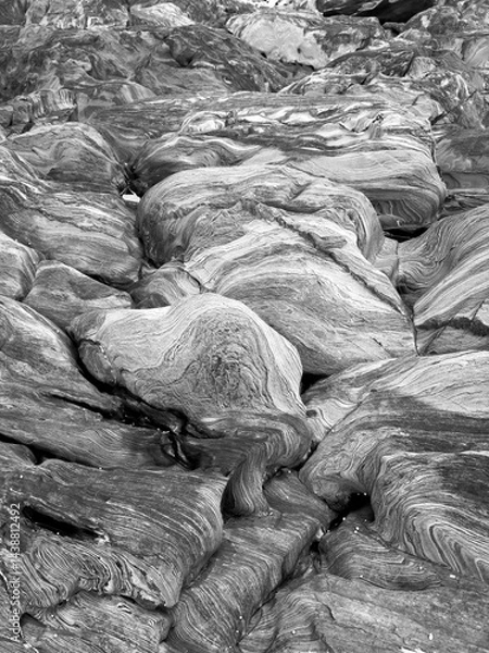 Fototapeta Black and white abstract background of natural rock shapes and patterns with swirls and lines running through the granite