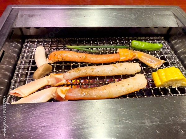 Fototapeta Close up of crab legs and vegetables being barbecued in grill