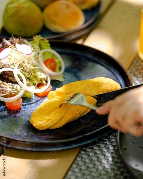 Fototapeta Savor a fluffy breakfast omelette with fresh salad at a cozy morning  gourmet food photography captures inviting atmosphere for a perfect start