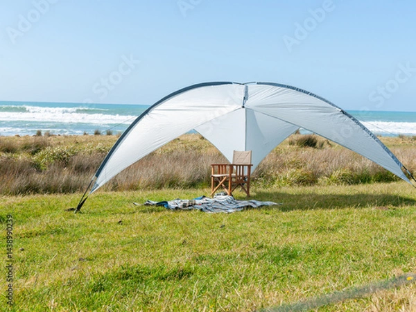 Obraz Sunshade erected on grass with beach background