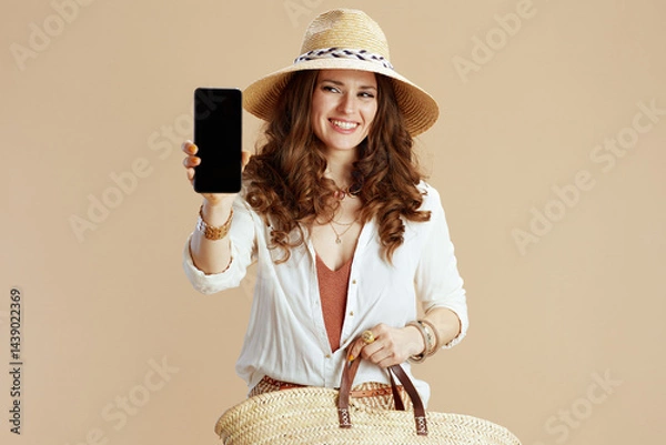 Obraz happy woman showing smartphone blank screen on beige
