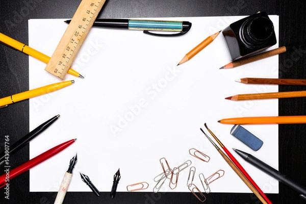 Fototapeta Office supplies on the background of a white sheet of paper. A ready-made background for a sample of text.
