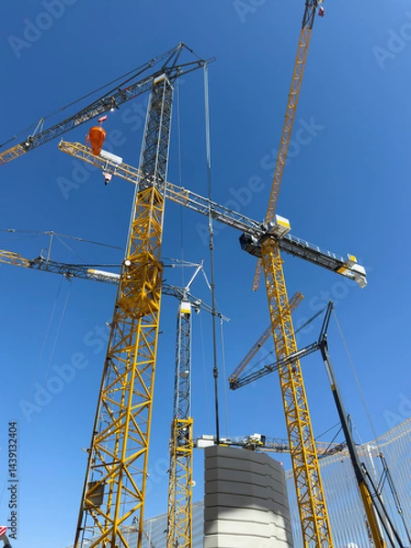 Fototapeta Construction cranes. View from below. Crane used to construct palaces, houses or buildings. Construction site. General contest