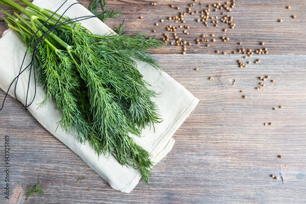 Fototapeta Bunch of fresh dill herbs and coriander seeds on wooden table, top view, copy space.